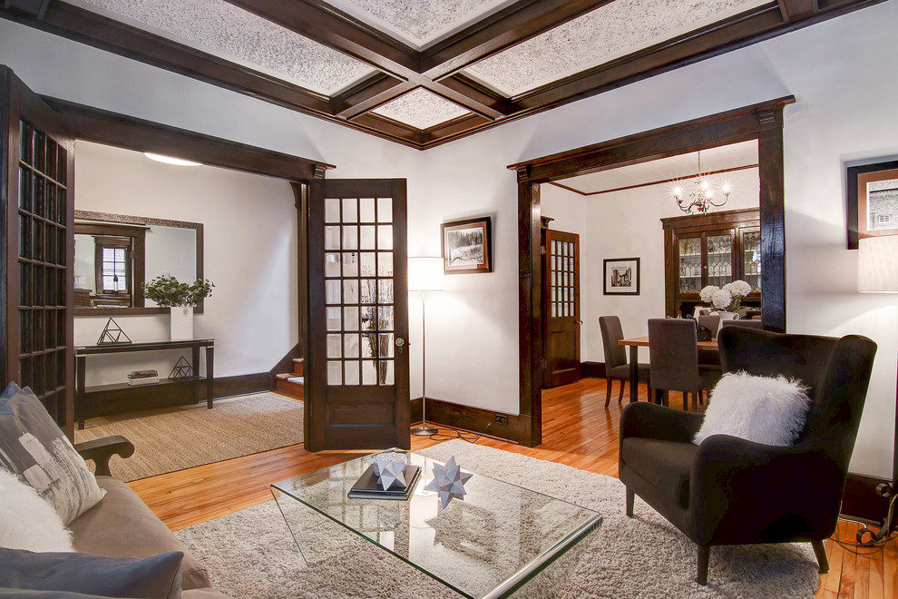 Small traditional formal enclosed living room in Montreal with white walls, light hardwood floors, a standard fireplace, a brick fireplace surround and brown floor.