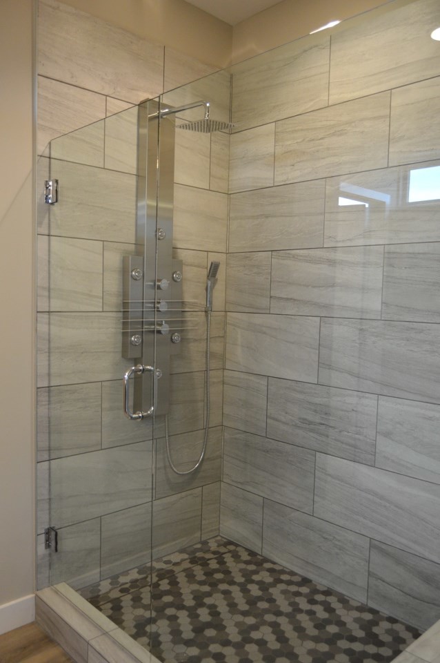Photo of a large contemporary master bathroom in Kansas City with an alcove shower, ceramic tile, beige walls, ceramic floors, brown floor and a hinged shower door.
