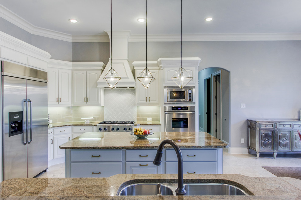 Inspiration for a large transitional eat-in kitchen in Dallas with an undermount sink, raised-panel cabinets, grey cabinets, granite benchtops, beige splashback, subway tile splashback, stainless steel appliances, travertine floors, multiple islands, beige floor and brown benchtop.