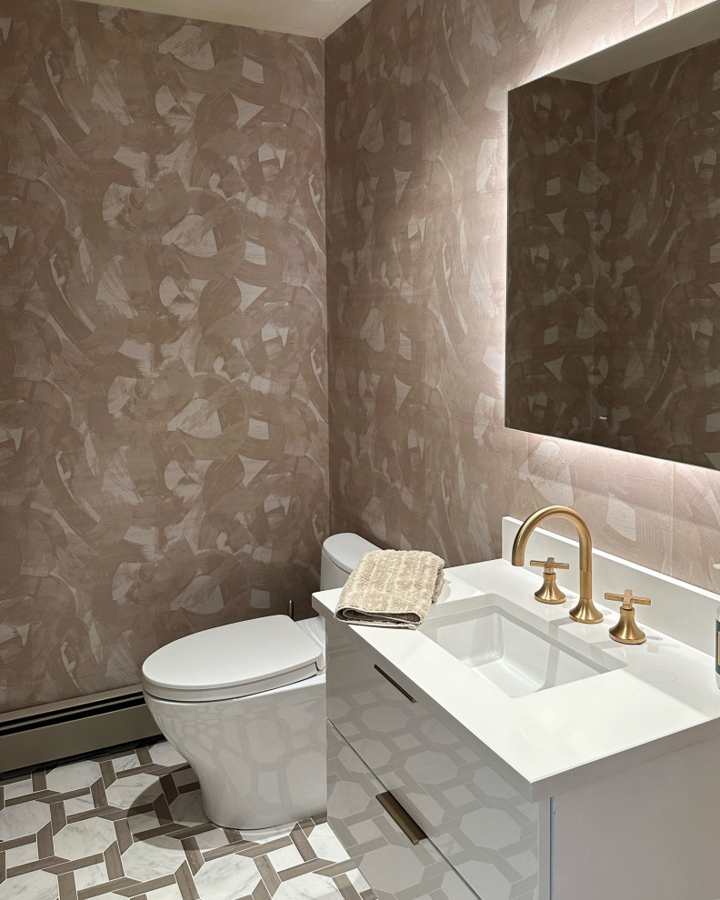 Modern inredning av ett litet toalett, med släta luckor, vita skåp, en bidé, rosa kakel, rosa väggar, klinkergolv i porslin, ett nedsänkt handfat, bänkskiva i kalksten och vitt golv