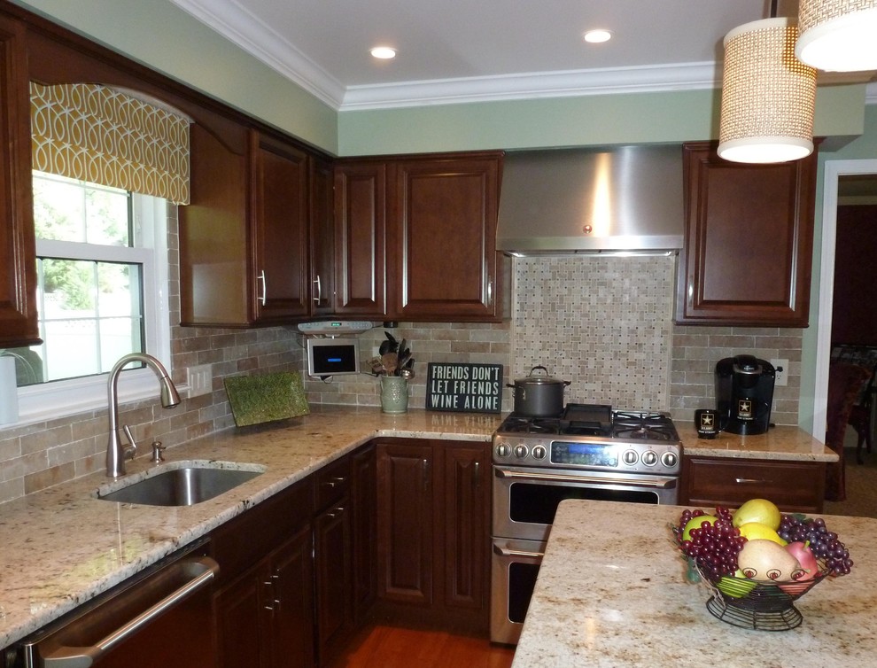 Photo of a mid-sized traditional l-shaped eat-in kitchen in Philadelphia with an undermount sink, raised-panel cabinets, medium wood cabinets, granite benchtops, ceramic splashback, stainless steel appliances, medium hardwood floors and with island.
