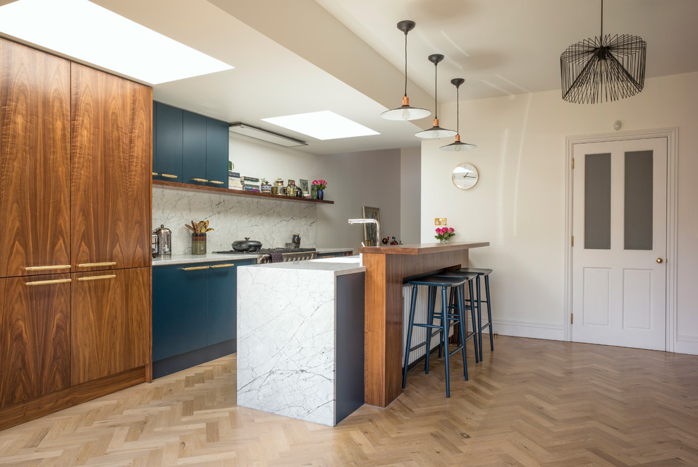 Design ideas for a mid-sized contemporary galley eat-in kitchen in London with an undermount sink, flat-panel cabinets, white splashback, light hardwood floors, a peninsula and beige floor.