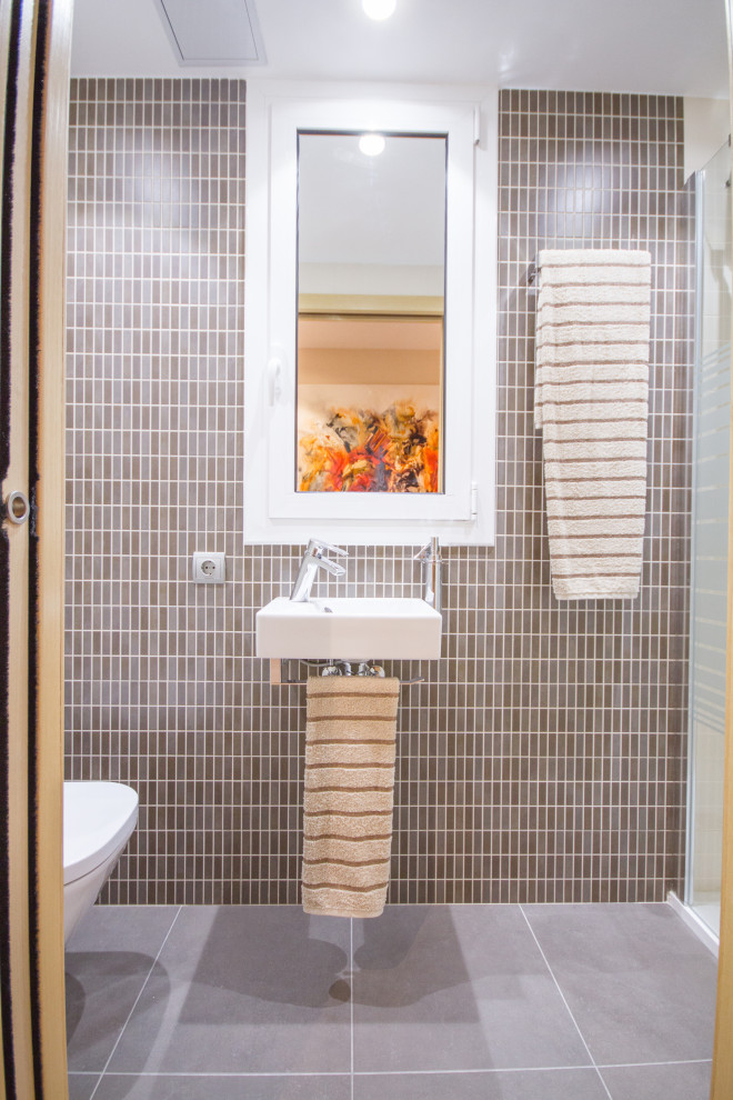Modelo de aseo actual pequeño con baldosas y/o azulejos beige, baldosas y/o azulejos de cerámica, paredes beige, suelo de baldosas de cerámica, lavabo suspendido y suelo marrón