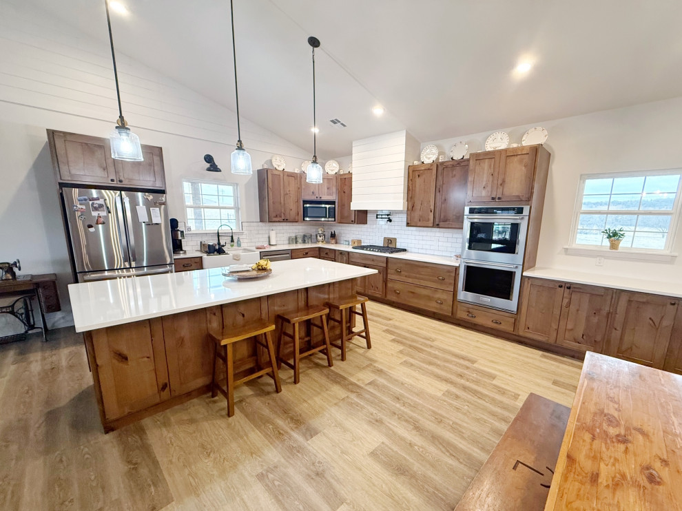 Eat-in kitchen - mid-sized rustic l-shaped eat-in kitchen idea with a farmhouse sink, shaker cabinets, quartz countertops, white backsplash, stainless steel appliances, an island and white countertops