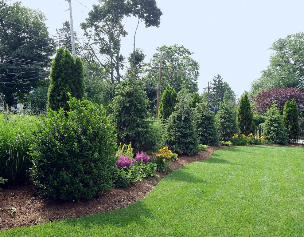 Photo of a large traditional backyard full sun formal garden for summer in New York.