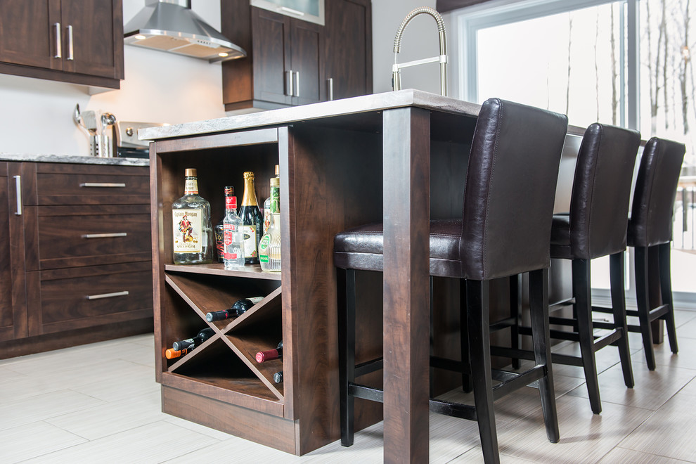 Example of a mid-sized trendy galley porcelain tile enclosed kitchen design in Montreal with a double-bowl sink, shaker cabinets, brown cabinets, laminate countertops, white backsplash, ceramic backsplash, stainless steel appliances and an island