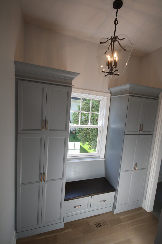 Example of a mid-sized transitional light wood floor and brown floor hallway design in Chicago with white walls