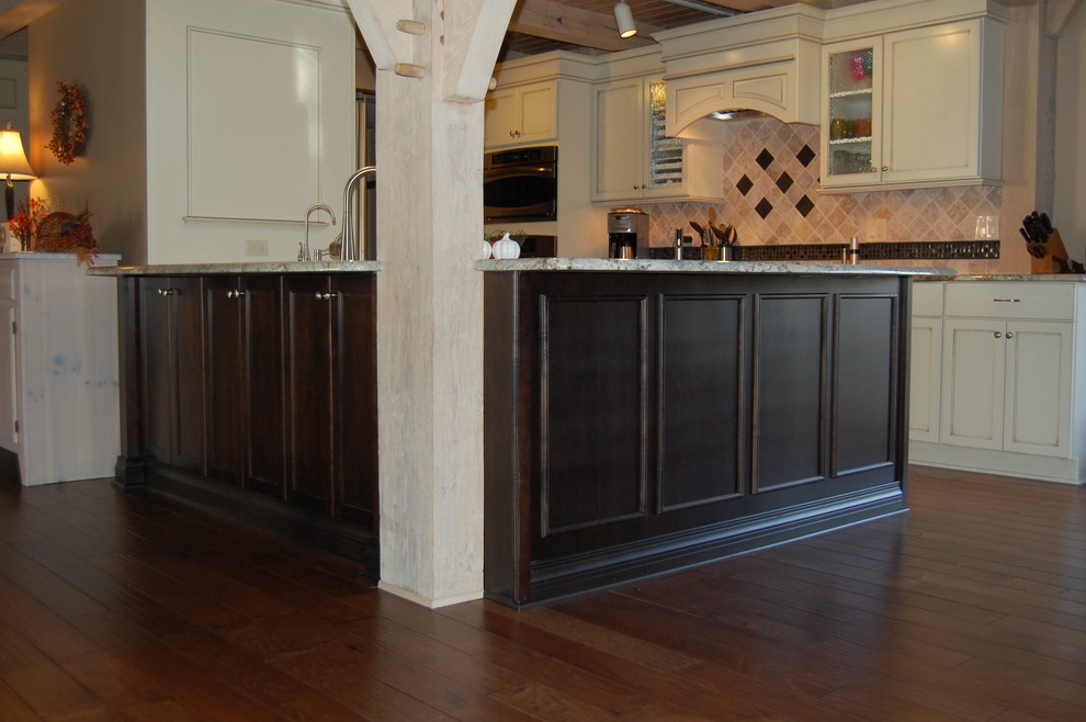 Example of a mid-sized transitional u-shaped medium tone wood floor open concept kitchen design in Chicago with an undermount sink, flat-panel cabinets, dark wood cabinets, granite countertops, beige backsplash, stone tile backsplash, stainless steel appliances and a peninsula