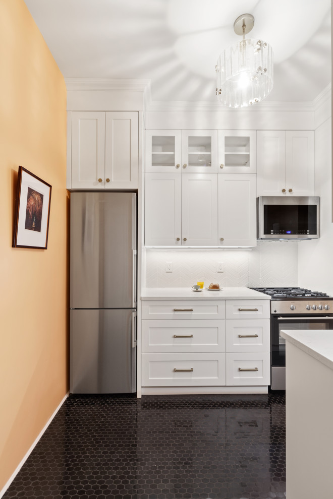 ニューヨークにある高級な小さなコンテンポラリースタイルのおしゃれなキッチン (シングルシンク、シェーカースタイル扉のキャビネット、白いキャビネット、人工大理石カウンター、白いキッチンパネル、磁器タイルのキッチンパネル、シルバーの調理設備、ライムストーンの床、アイランドなし、黒い床、白いキッチンカウンター) の写真
