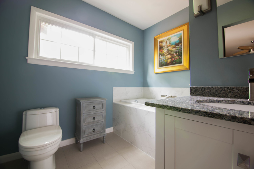 Inspiration for a large transitional master white tile and ceramic tile ceramic tile and beige floor drop-in bathtub remodel in Atlanta with shaker cabinets, white cabinets, a one-piece toilet, blue walls, an undermount sink and granite countertops