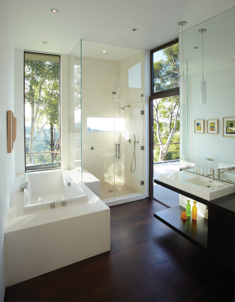 Photo of a mid-sized modern master bathroom in Los Angeles with a vessel sink, open cabinets, dark wood cabinets, wood benchtops, a drop-in tub, a corner shower, beige tile, stone tile, white walls and dark hardwood floors.