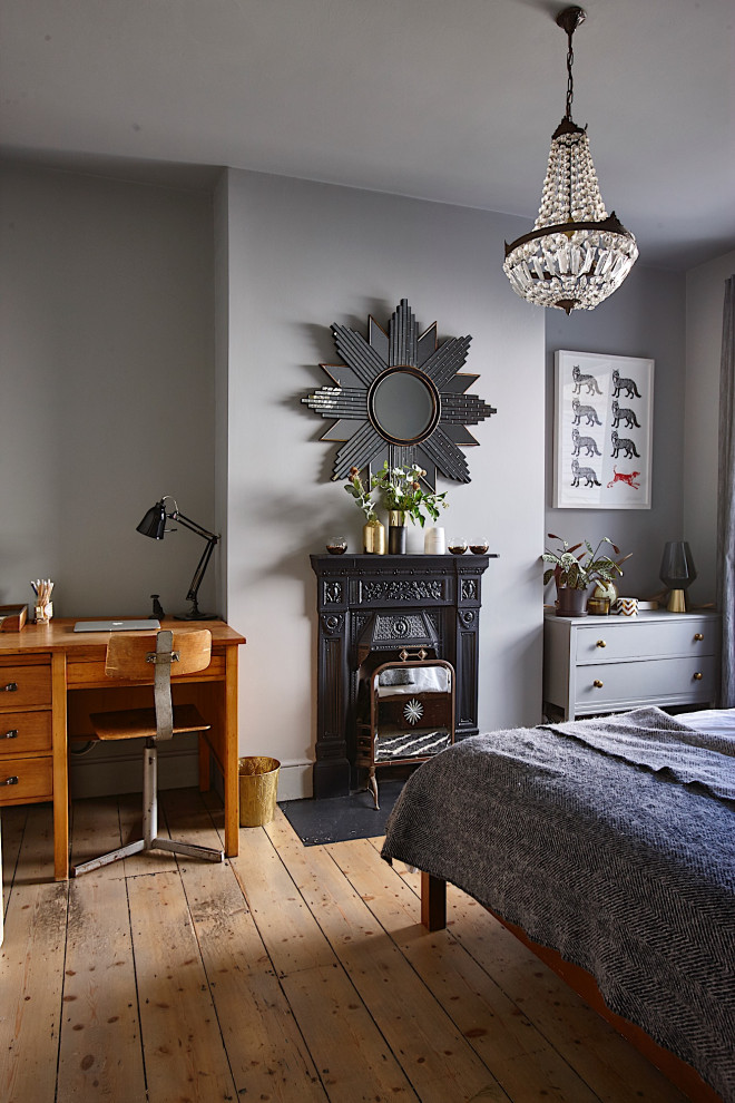 Cette photo montre un petit bureau éclectique avec un mur gris, parquet clair, une cheminée standard, un manteau de cheminée en métal, un bureau indépendant et un sol beige.