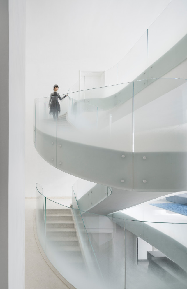 Идея дизайна: огромная изогнутая лестница в современном стиле с мраморными ступенями, подступенками из мрамора и стеклянными перилами