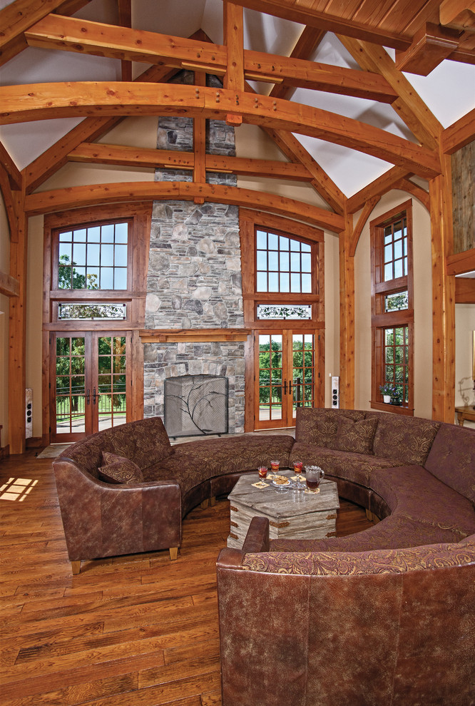 Photo of a large traditional open concept family room in Other with beige walls, a standard fireplace, a stone fireplace surround and medium hardwood floors.
