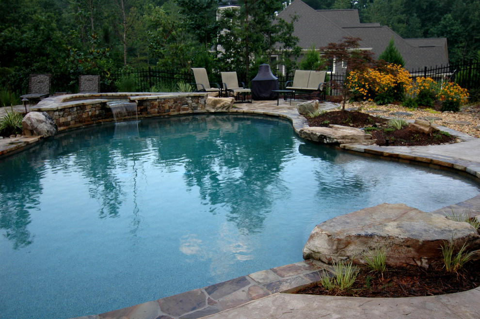 Example of a mid-sized mountain style backyard stone and kidney-shaped hot tub design in Atlanta