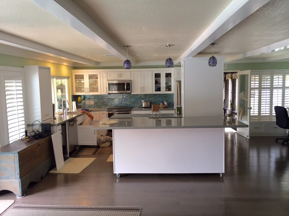 This is an example of a mid-sized transitional u-shaped eat-in kitchen in San Diego with a double-bowl sink, raised-panel cabinets, white cabinets, soapstone benchtops, multi-coloured splashback, mosaic tile splashback, stainless steel appliances, light hardwood floors, no island and blue floor.