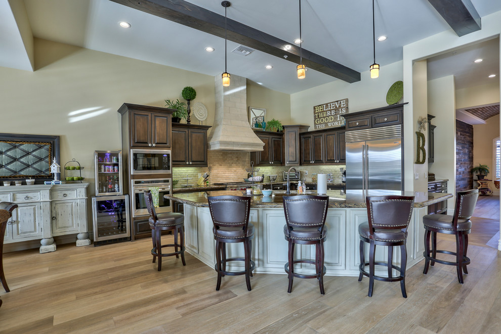 Transitional eat-in kitchen photo in Phoenix with beige backsplash and an island