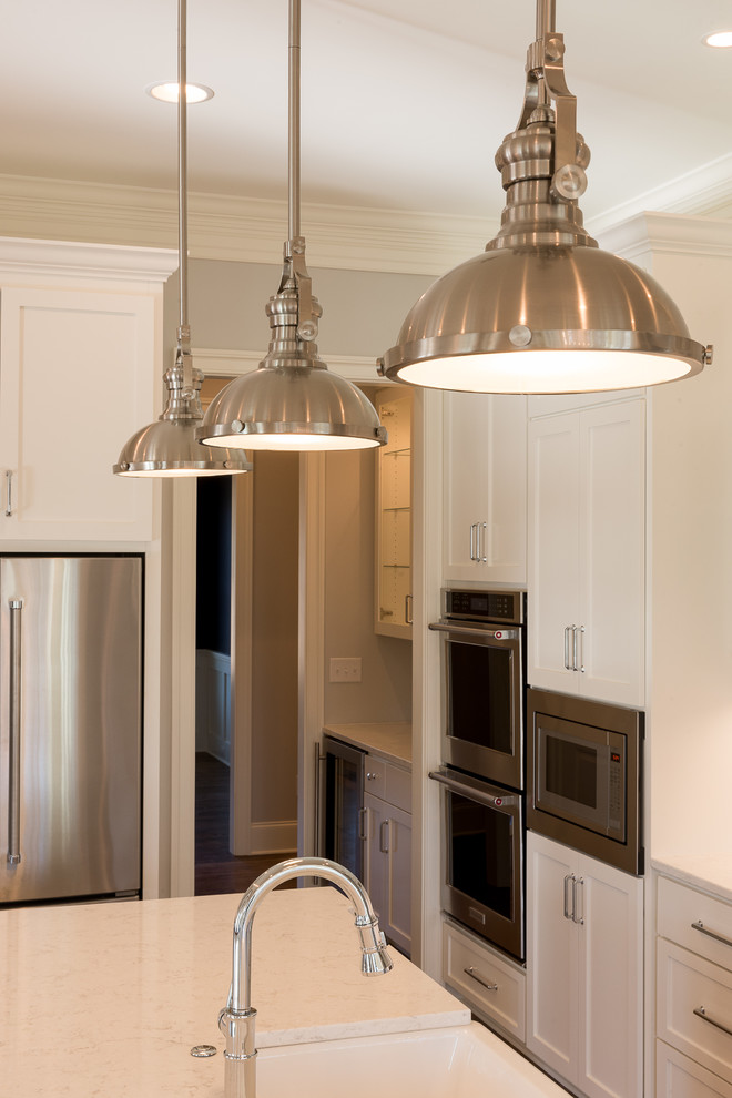 Mid-sized transitional l-shaped dark wood floor and brown floor open concept kitchen photo with shaker cabinets, white cabinets, granite countertops, stainless steel appliances, an island and a farmhouse sink