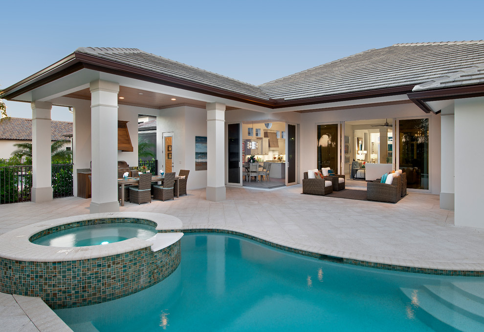 Design ideas for a large tropical one-storey stucco grey exterior in Tampa with a gable roof.