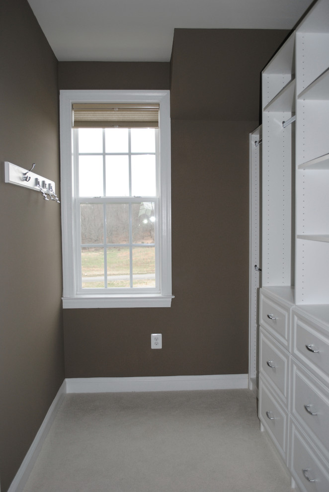 Mid-sized traditional walk-in wardrobe in DC Metro with raised-panel cabinets, white cabinets and carpet.