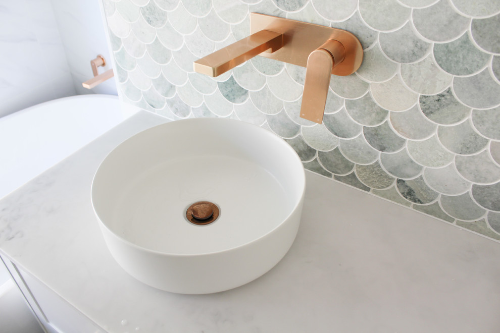 This is an example of a mid-sized contemporary kids bathroom in Perth with flat-panel cabinets, white cabinets, a freestanding tub, a corner shower, white tile, porcelain tile, white walls, porcelain floors, a vessel sink, marble benchtops, grey floor, a hinged shower door and grey benchtops.