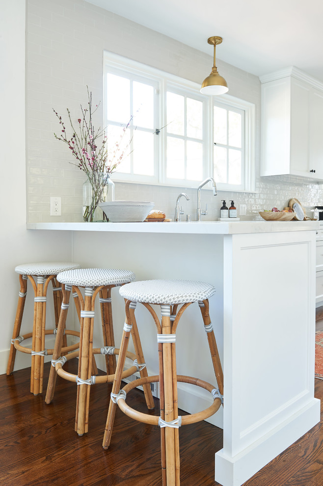 Inspiration for a mid-sized coastal galley medium tone wood floor and brown floor eat-in kitchen remodel in San Diego with an undermount sink, shaker cabinets, white cabinets, quartz countertops, gray backsplash, ceramic backsplash, stainless steel appliances, an island and white countertops
