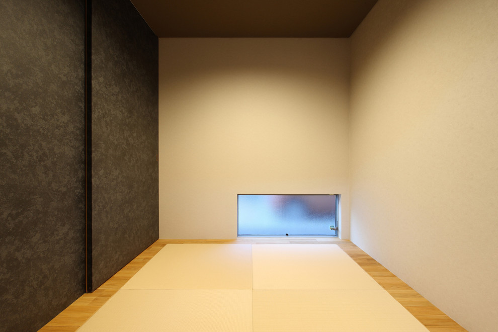 Modelo de habitación de invitados minimalista de tamaño medio sin chimenea con paredes beige, tatami, suelo marrón, papel pintado y papel pintado