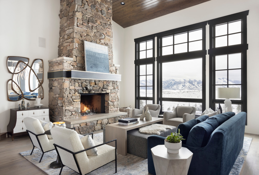 Inspiration for a transitional living room in Salt Lake City with white walls, light hardwood floors, a standard fireplace, a stone fireplace surround, beige floor, vaulted and wood.