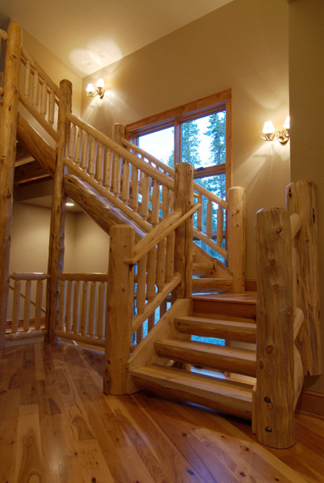 Example of a large mountain style wooden u-shaped open staircase design in Denver