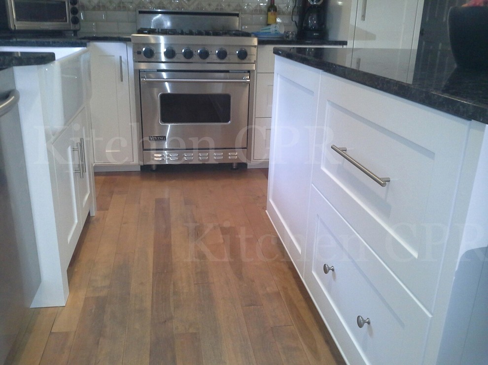 Mid-sized transitional light wood floor eat-in kitchen photo in Boston with a farmhouse sink, recessed-panel cabinets, white cabinets and stainless steel appliances