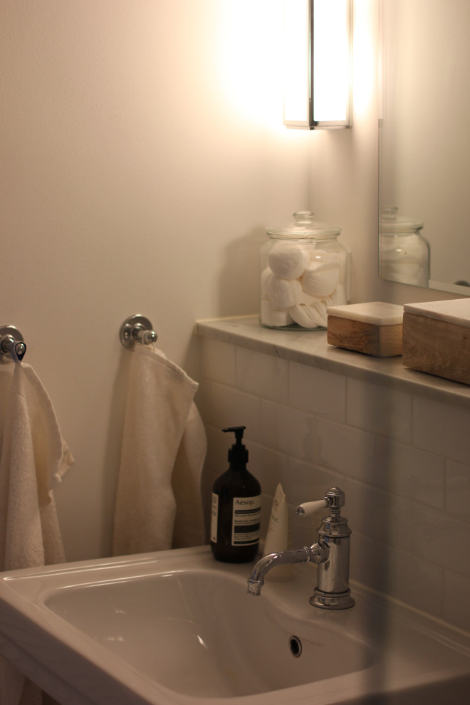 Inspiration för små klassiska badrum med dusch, med en kantlös dusch, en vägghängd toalettstol, vit kakel, keramikplattor, vita väggar, marmorgolv, ett konsol handfat, vitt golv och med dusch som är öppen