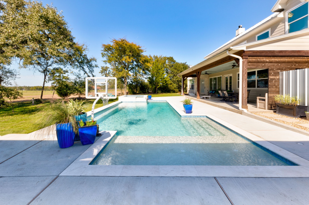 Bild på en mellanstor funkis anpassad pool på baksidan av huset, med spabad och naturstensplattor