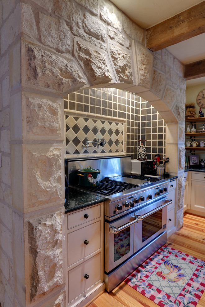 Mid-sized mountain style galley light wood floor kitchen photo in Austin with flat-panel cabinets, white cabinets, granite countertops, stainless steel appliances and an island