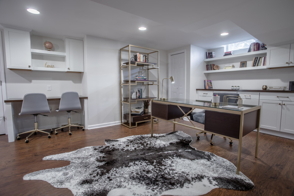 Esempio di uno studio moderno con pareti bianche, parquet chiaro, scrivania autoportante e pavimento marrone