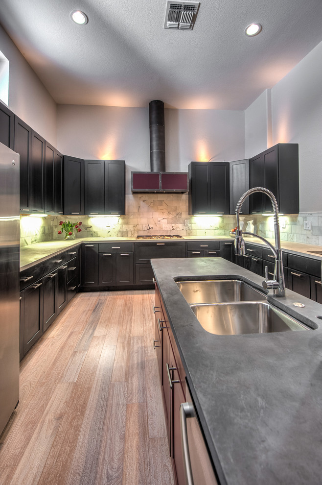 This is an example of a mid-sized contemporary u-shaped eat-in kitchen in Sacramento with shaker cabinets, dark wood cabinets, concrete benchtops, grey splashback, stone tile splashback, stainless steel appliances, light hardwood floors and with island.