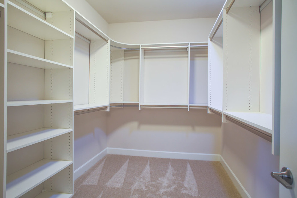 Traditional gender-neutral walk-in wardrobe in Seattle with carpet and beige floor.