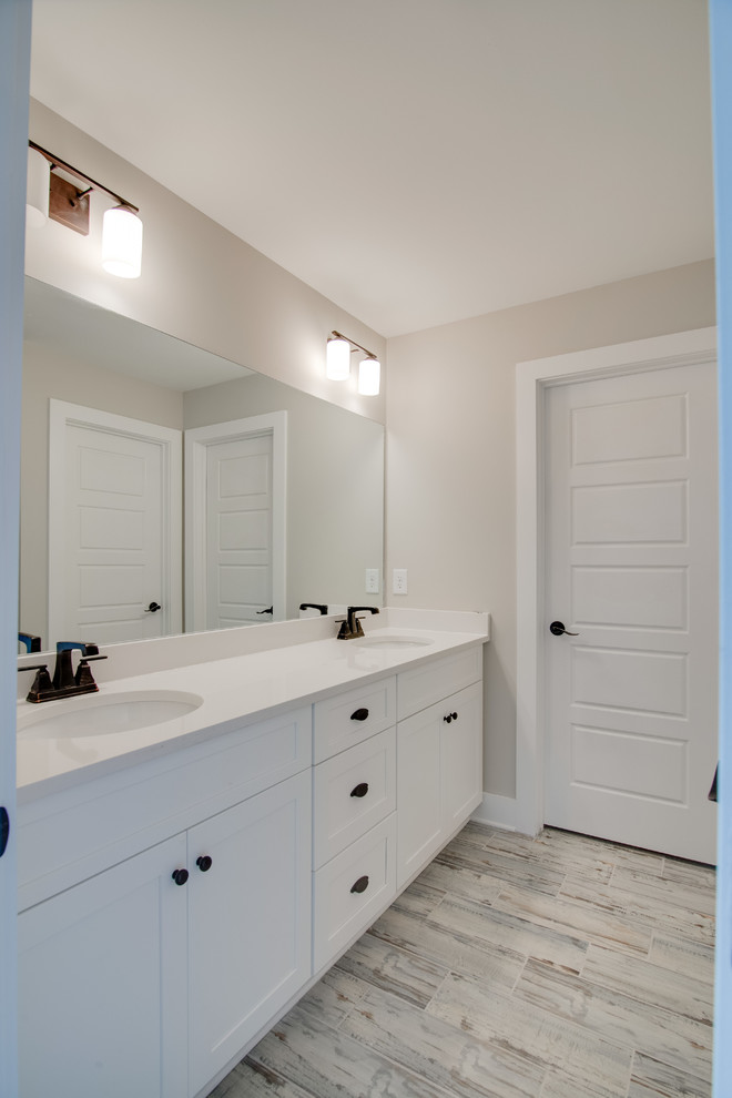 Design ideas for a large traditional master bathroom in Nashville with white cabinets, white tile, quartzite benchtops, an alcove shower, beige walls and porcelain floors.