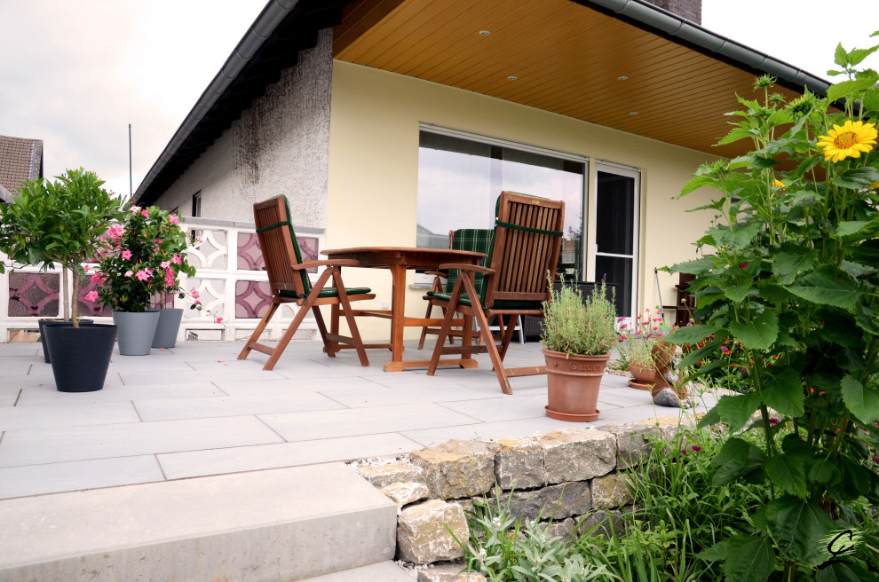 This is an example of a mid-sized traditional side yard partial sun garden for summer in Frankfurt with natural stone pavers.
