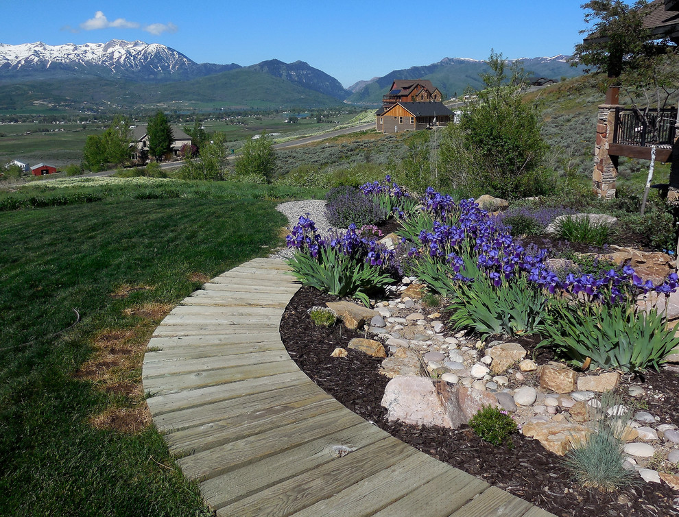 This is an example of a mid-sized transitional side yard full sun xeriscape for spring in Salt Lake City with a garden path and decking.