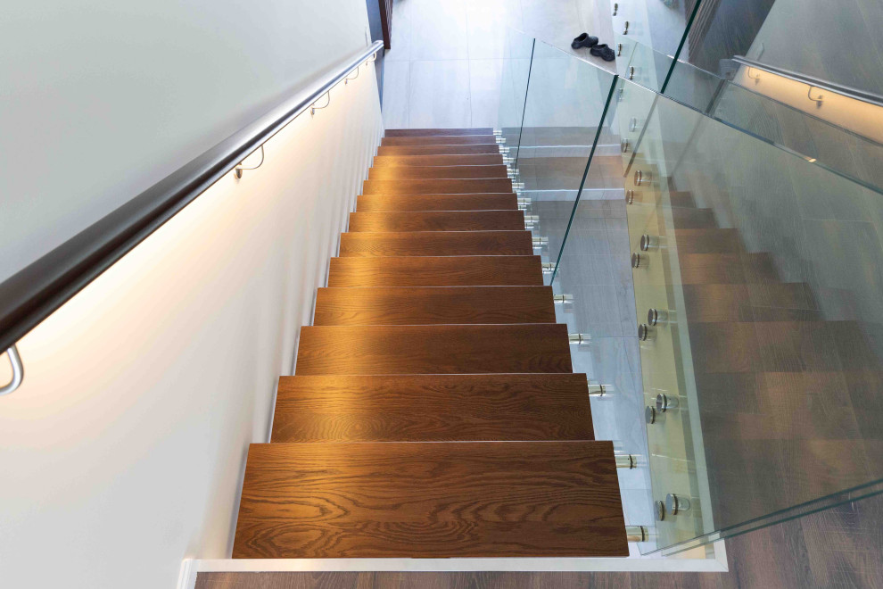 Ejemplo de escalera suspendida minimalista de tamaño medio sin contrahuella con escalones de madera y barandilla de madera