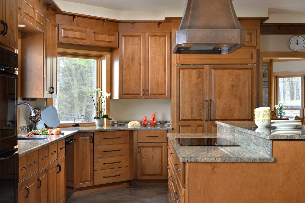 This is an example of a traditional kitchen in New York with an undermount sink, raised-panel cabinets, medium wood cabinets, panelled appliances and with island.