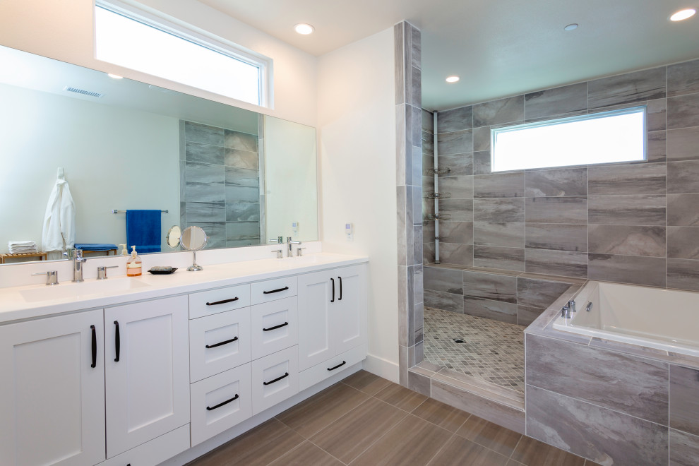 Design ideas for a transitional master bathroom with white cabinets, a drop-in tub, ceramic floors, an integrated sink, brown floor, white benchtops, a shower seat and a double vanity.