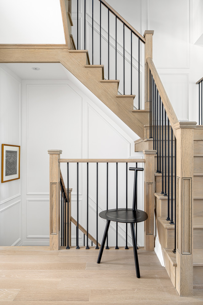 Ejemplo de escalera en U contemporánea grande con escalones de madera, contrahuellas de madera, barandilla de metal y panelado