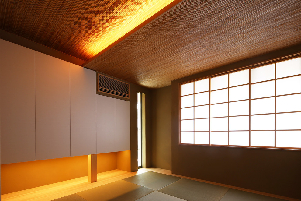 Design ideas for a mid-sized asian guest bedroom in Tokyo with white walls, tatami floors, no fireplace and beige floor.