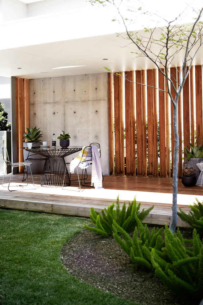 Photo of a mid-sized contemporary backyard deck in Sydney with a roof extension.