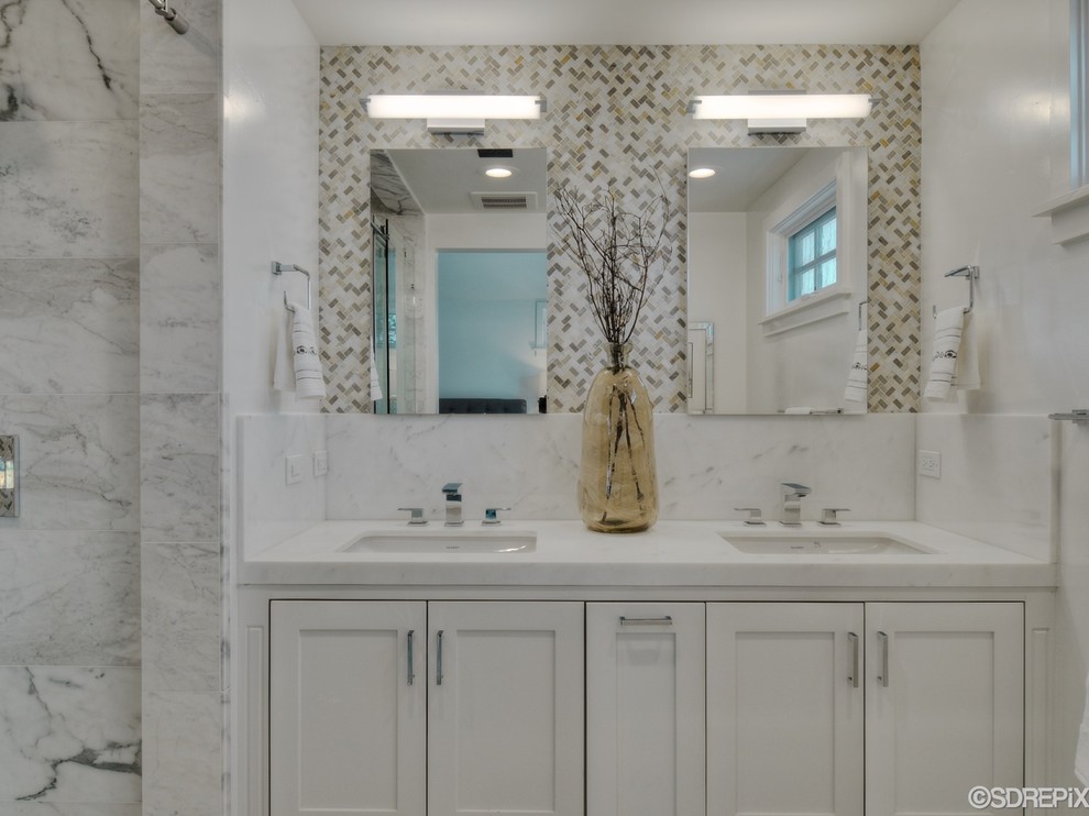 Small beach style master bathroom in San Diego with an undermount sink, shaker cabinets, white cabinets, marble benchtops, an alcove tub, a shower/bathtub combo, a wall-mount toilet, white tile, stone tile, white walls and marble floors.