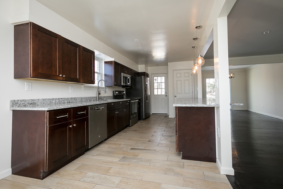 Open concept kitchen - mid-sized transitional galley beige floor and porcelain tile open concept kitchen idea in DC Metro with an undermount sink, shaker cabinets, dark wood cabinets, granite countertops, gray backsplash, stainless steel appliances, an island and gray countertops