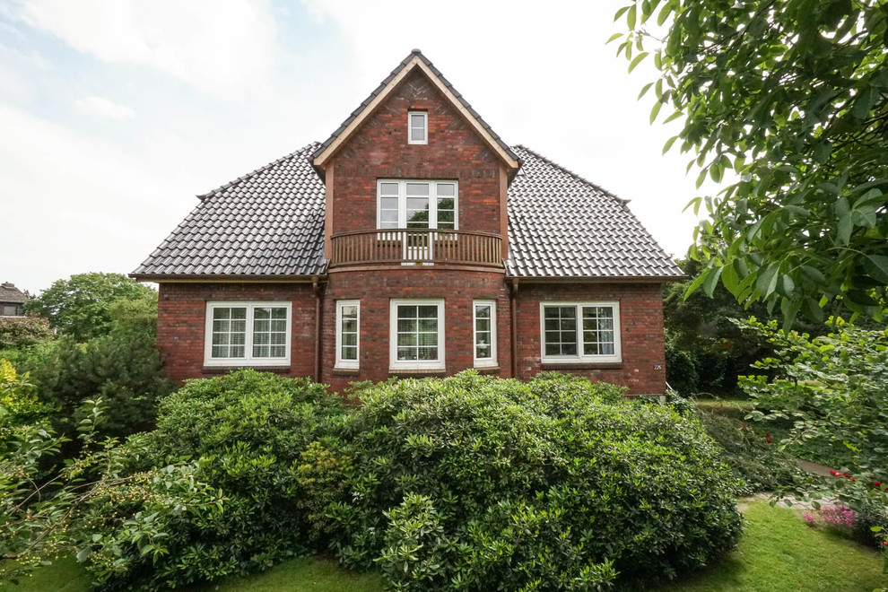 Inspiration for a traditional two-storey brick red house exterior in Hamburg with a gable roof and a tile roof.