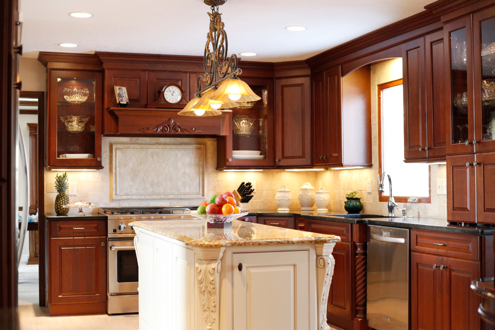 Inspiration for a large traditional u-shaped kitchen in Columbus with an undermount sink, raised-panel cabinets, medium wood cabinets, granite benchtops, beige splashback, stone tile splashback, stainless steel appliances, porcelain floors and with island.