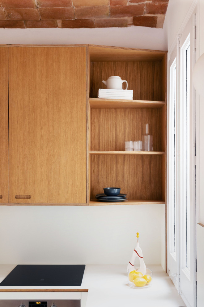 Foto på ett avskilt, mellanstort medelhavsstil vit l-kök, med en integrerad diskho, skåp i shakerstil, vita skåp, laminatbänkskiva, vitt stänkskydd, stänkskydd i keramik, rostfria vitvaror, plywoodgolv och brunt golv